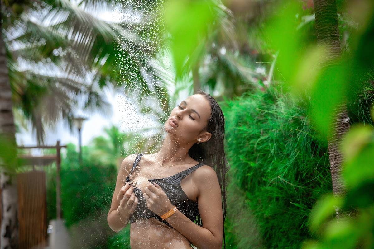 Woman applying moisturizing oil perfect skin care routine to her arms after a shower